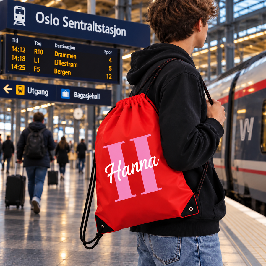 Rød GymSack med initial og navn båret som ryggsekk på Oslo S